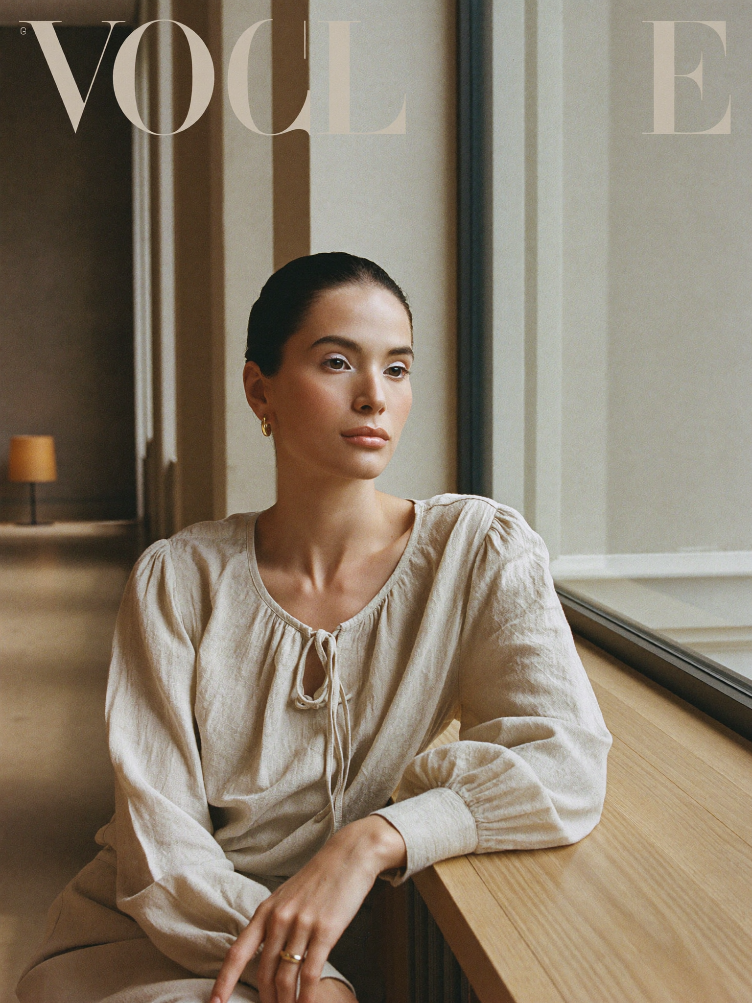 Mooi Muse editorial, woman seated by a window in an oatmeal linen blouse